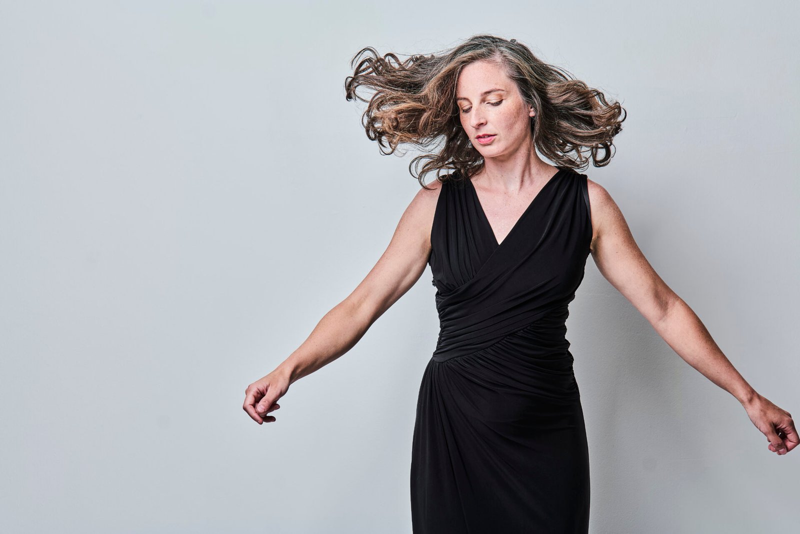 Portrait of soprano ylva sofia stenberg wearing a black dress and moving her hair and arms