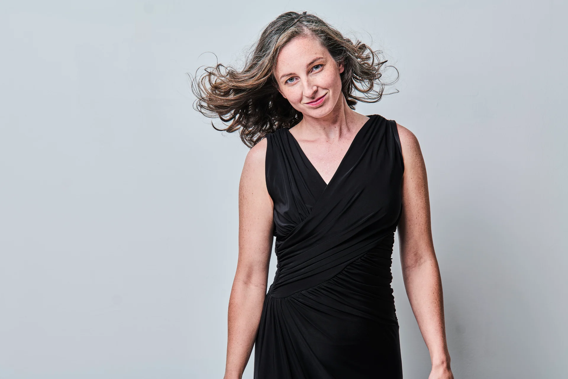 Portrait of Ylva Sofia Stenberg, wearing a black dress, flying hair